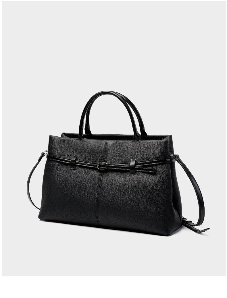 Black pebbled cowhide leather tote with shoulder strap on white background