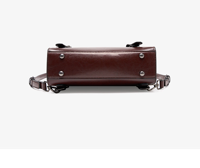 Bottom view of brown backpack showing feet and strap hardware