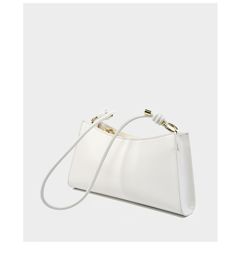 Cream white leather shoulder bag from side angle showing clean lines and strap