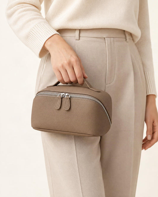 Cowhide Leather Travel Pouch with Top Handle held in hand by a model