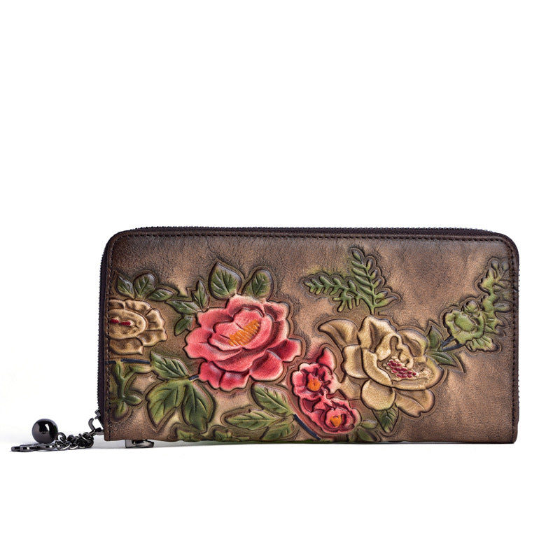 Side view of a floral embossed cowhide wallet with zip closure