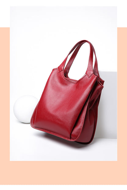 Wine red leather tote bag styled with a white sphere prop