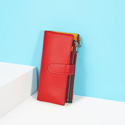 Red leather phone wallet propped against a white block on a turquoise background