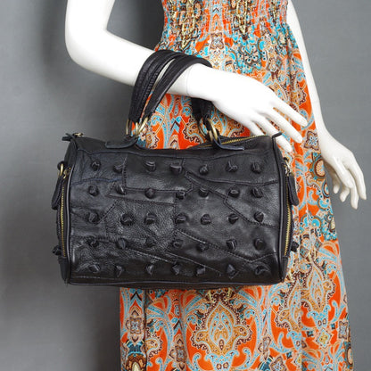 Black patchwork leather bag carried by its top handles
