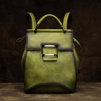 Green cowhide backpack with top handle, shoulder straps, and front flap