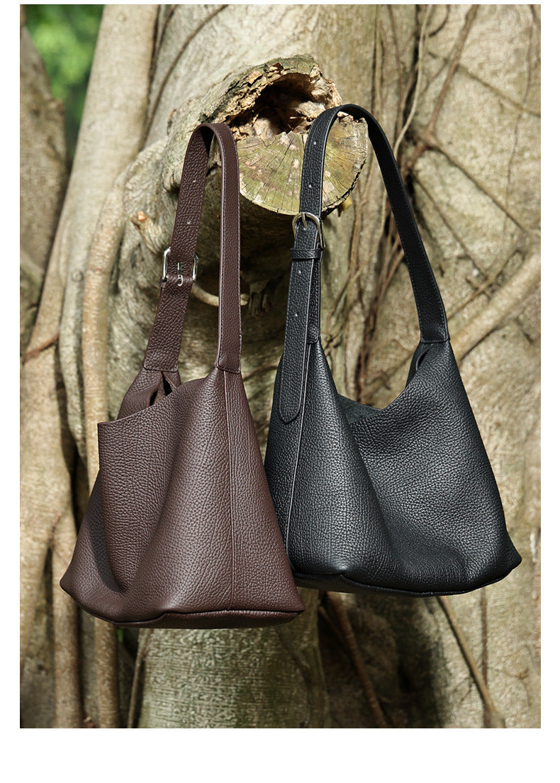 Side-by-side view of black and coffee brown hobo bags hanging outdoors