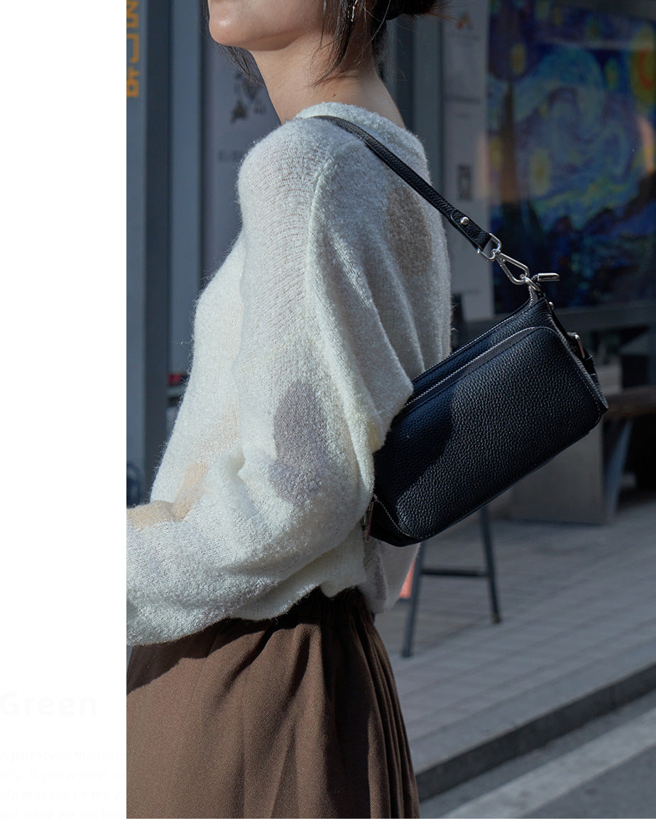 Black leather bag worn as shoulder bag by model
