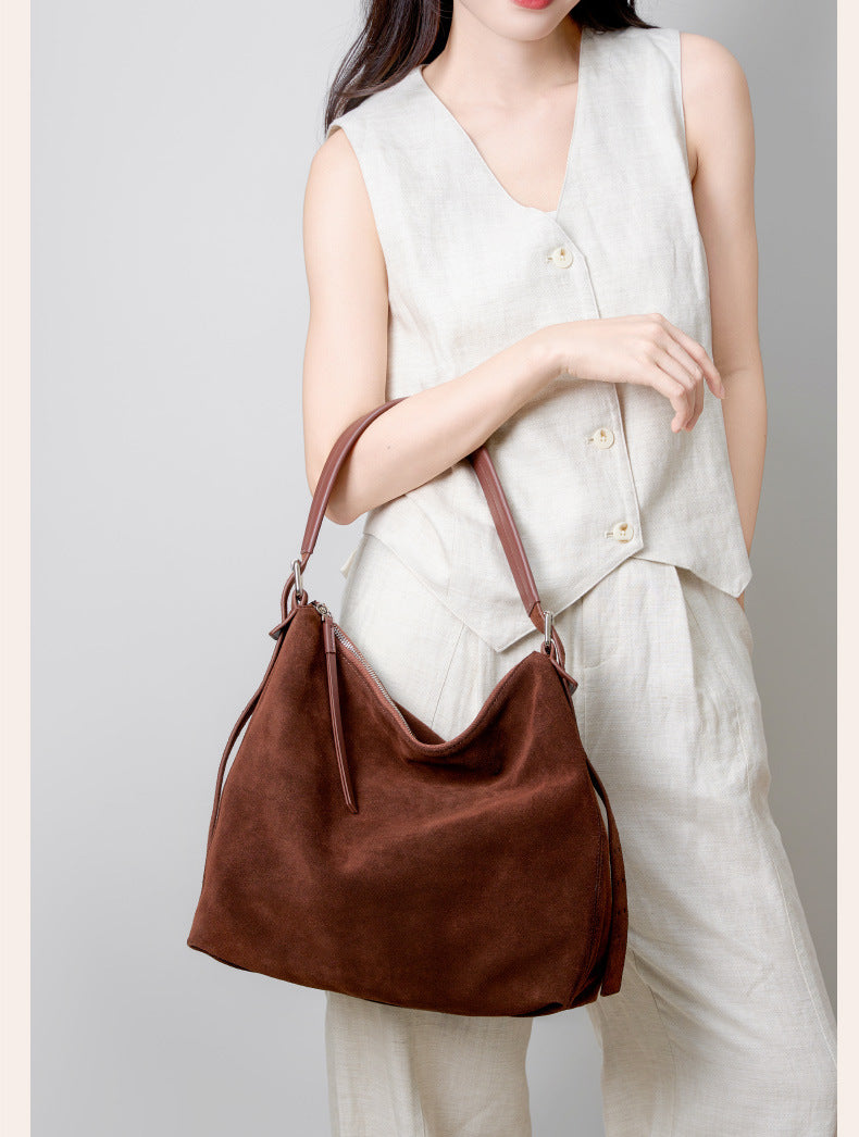 Model holding the tote by its shoulder strap