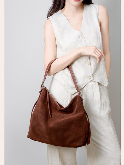 Model holding the tote by its shoulder strap
