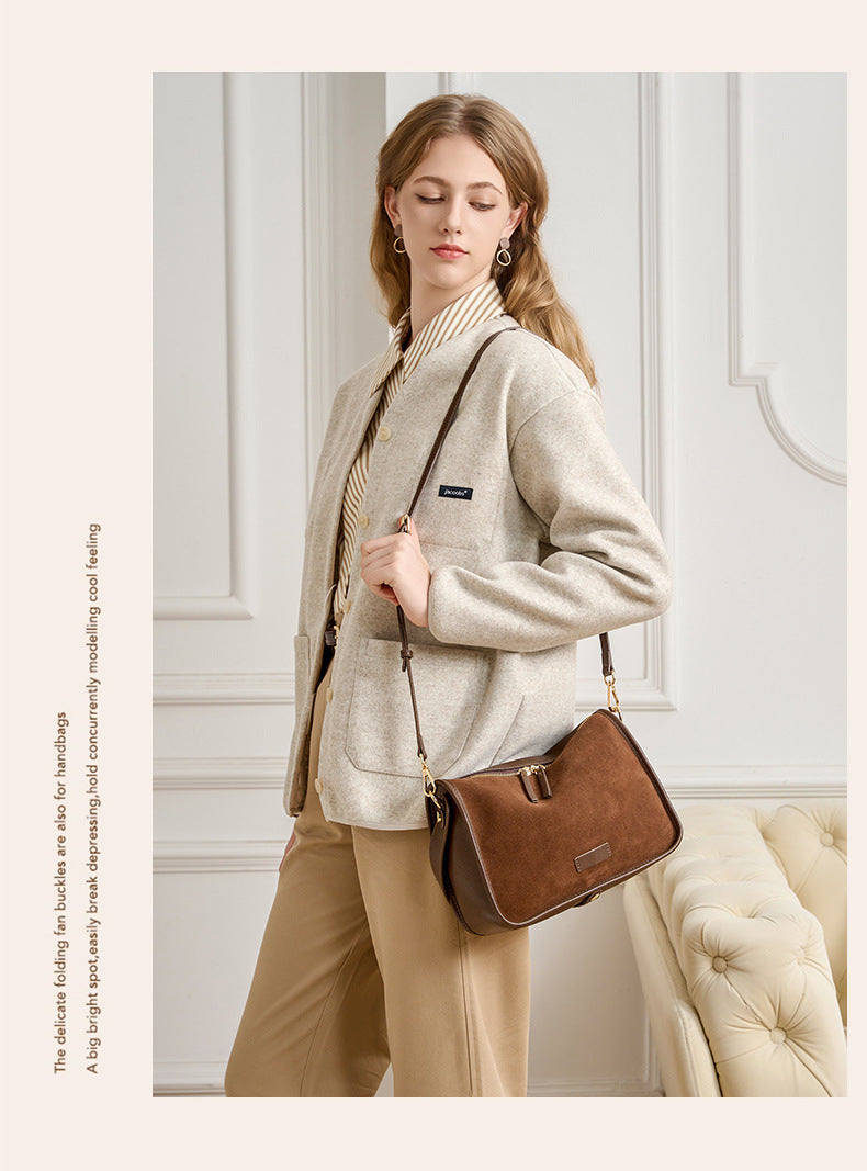 Brown crossbody bag with a zip closure and understated metal hardware