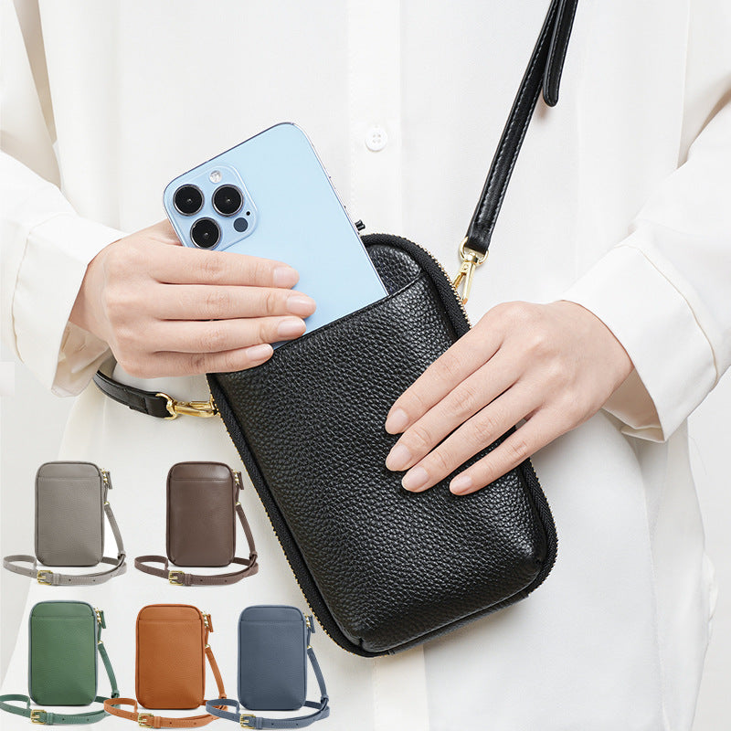 Lifestyle photo of black leather phone bag worn crossbody with smartphone in hand