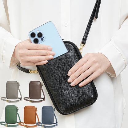 Lifestyle photo of black leather phone bag worn crossbody with smartphone in hand