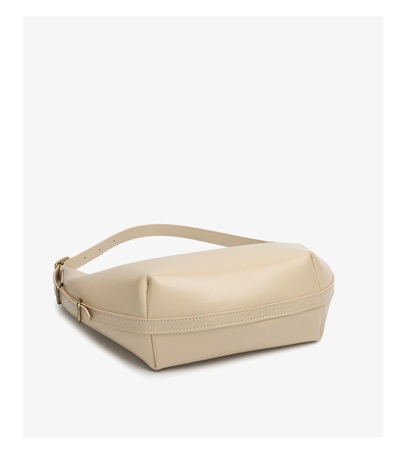 Bottom view of beige crescent bag showing base