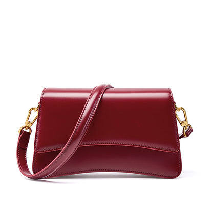 Side detail of wine red leather mini shoulder bag showing smooth finish and gold-tone hardware