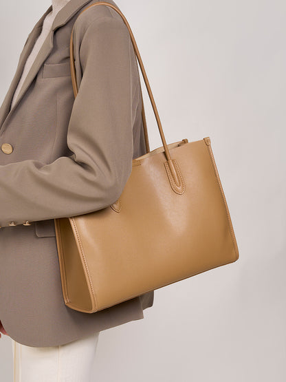 Light brown leather tote bag paired with a tailored blazer outfit