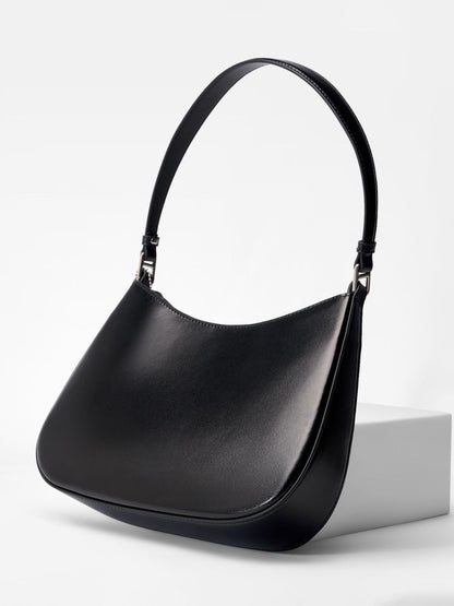 Black cowhide leather underarm shoulder bag shown at three-quarter angle on white pedestal