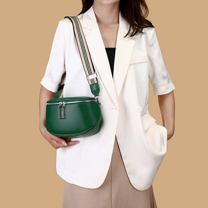 Green leather crossbody bag worn over the shoulder