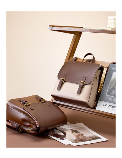 Both colorways of the backpack styled together on a wooden shelf and surface with printed lookbook pages