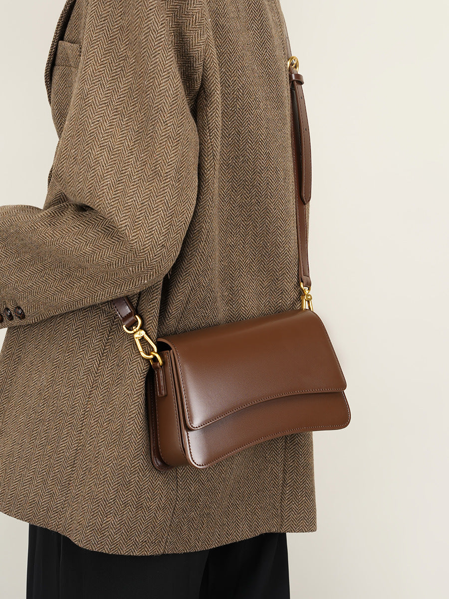 Model wearing brown leather mini bag as shoulder bag with herringbone blazer