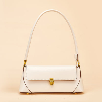 White cowhide baguette shoulder bag with antique brass lock on neutral background