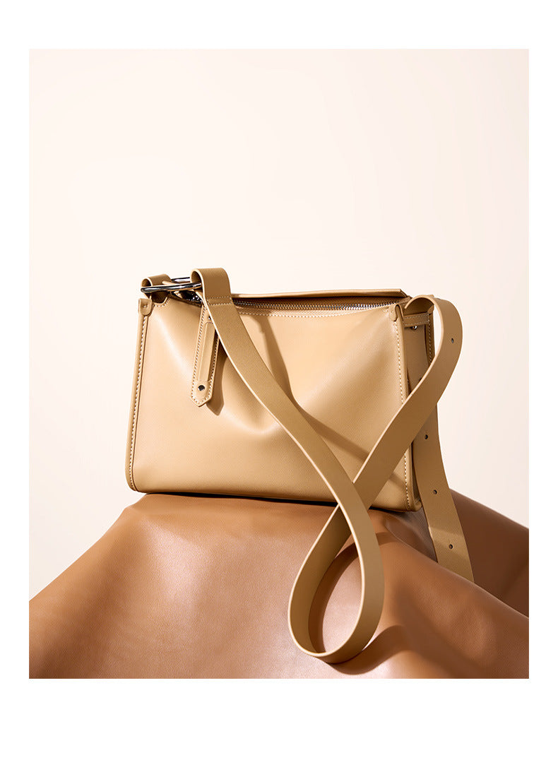 Apricot pillow bag styled on draped leather backdrop