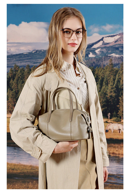 Model holding elephant gray bag near lake with mountains