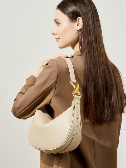 Model wearing camel blazer with off-white cowhide underarm bag in lifestyle side view