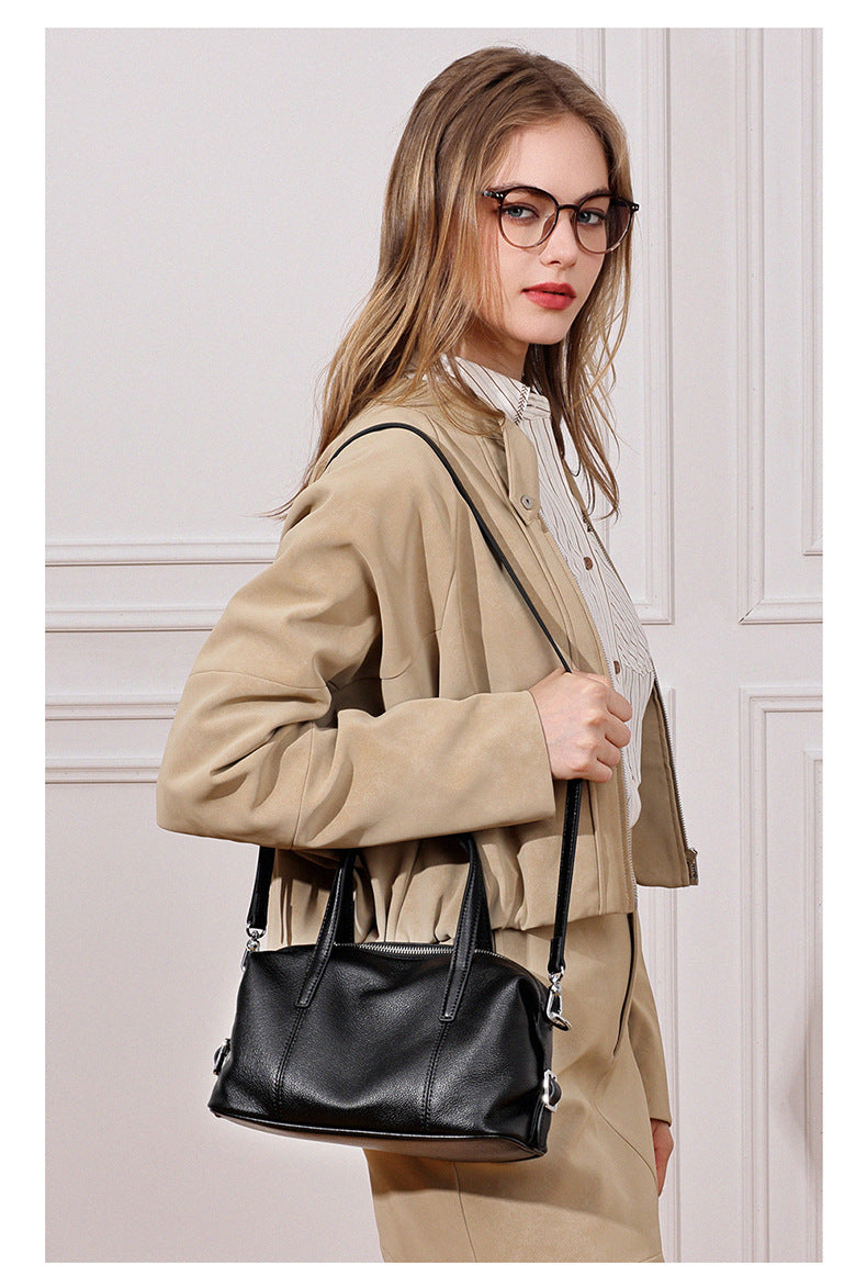 Model carrying black bag crossbody indoors
