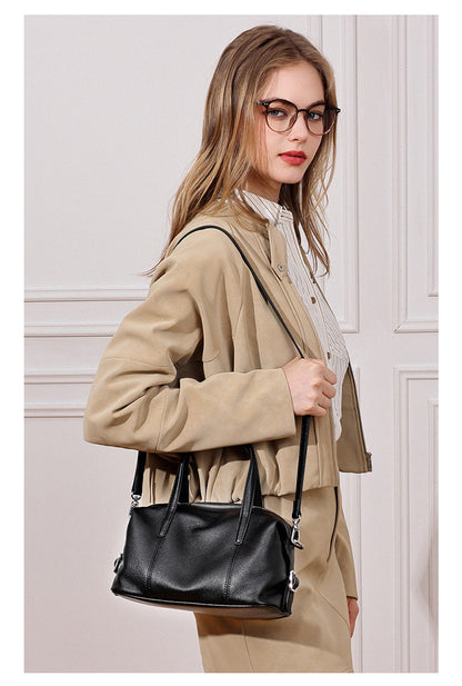 Model carrying black bag crossbody indoors