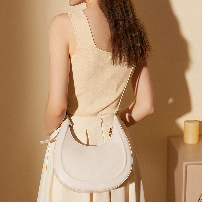 Back view of a cream white crescent bag worn over the shoulder
