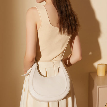Back view of a cream white crescent bag worn over the shoulder