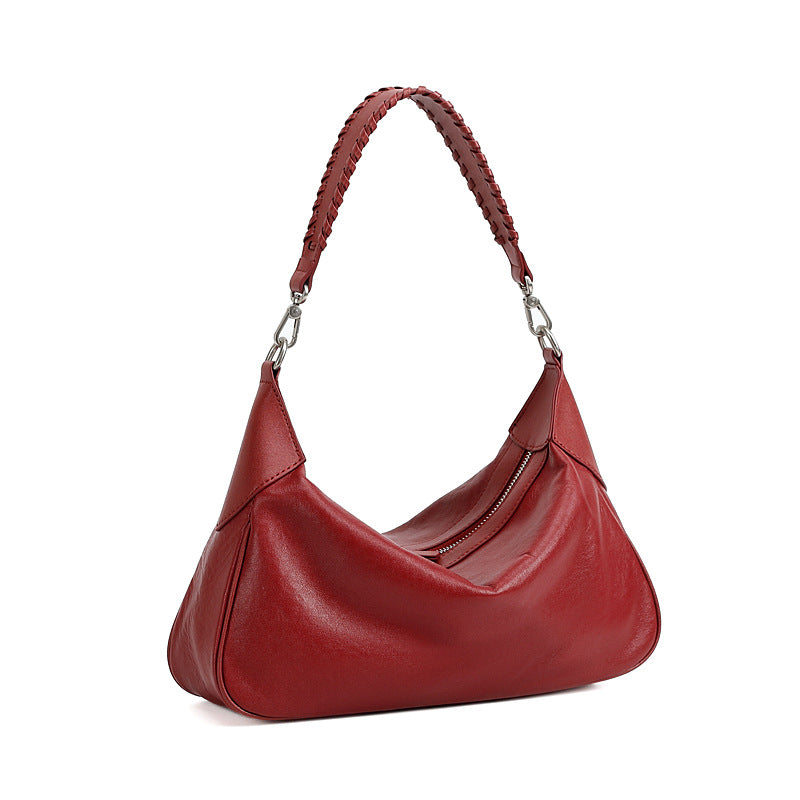 Red leather hobo shoulder bag with braided strap on white background