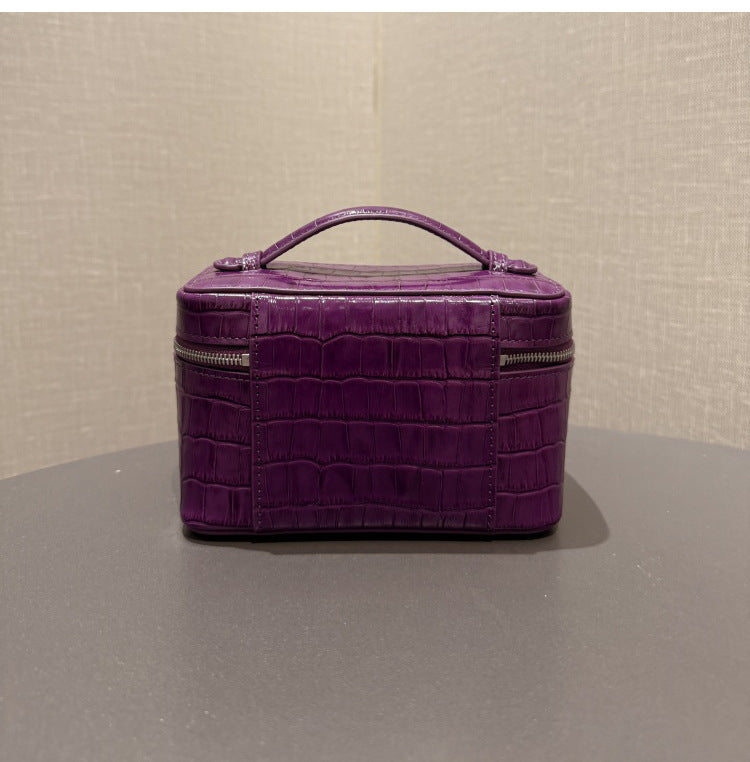 Angled side view of the purple leather cosmetic pouch