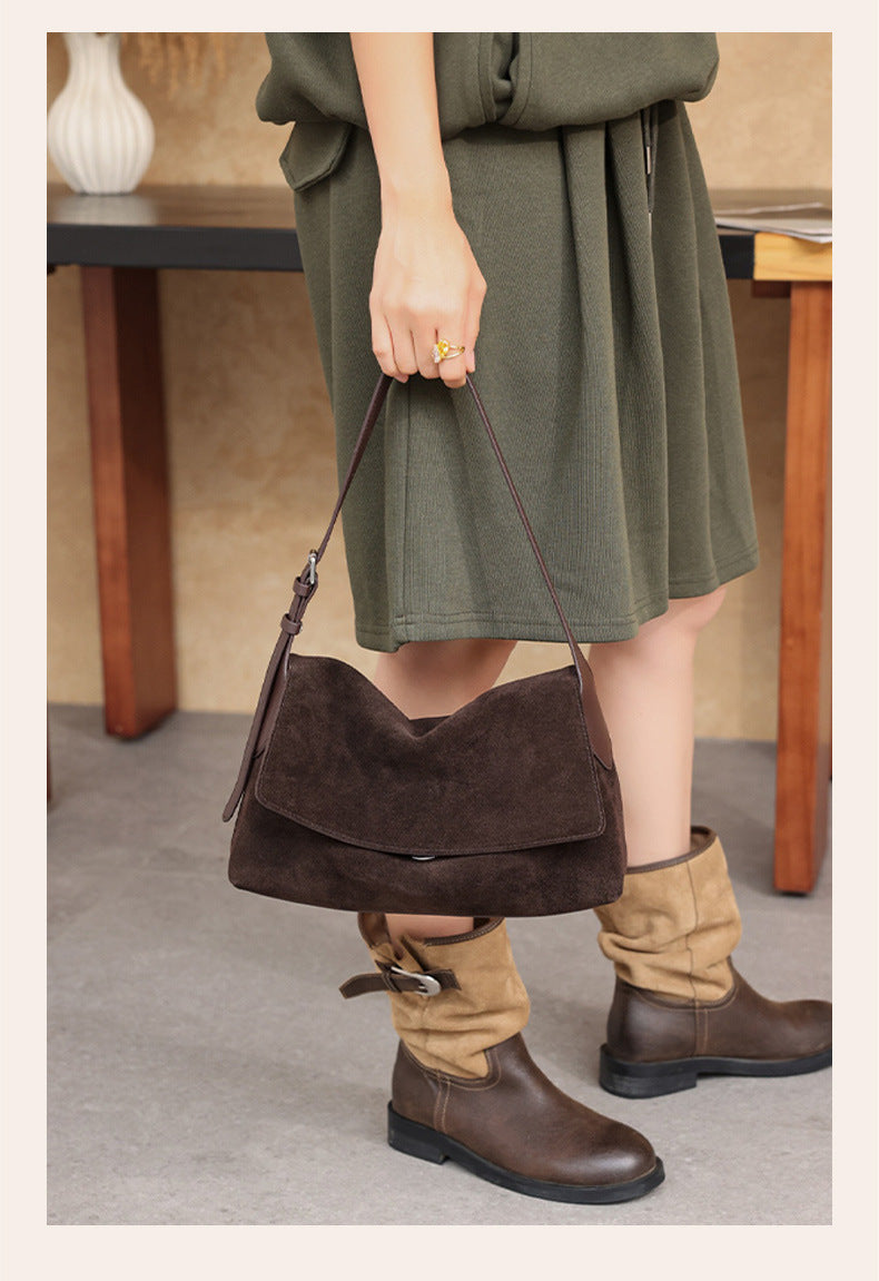 Brown leather shoulder bag carried at the side