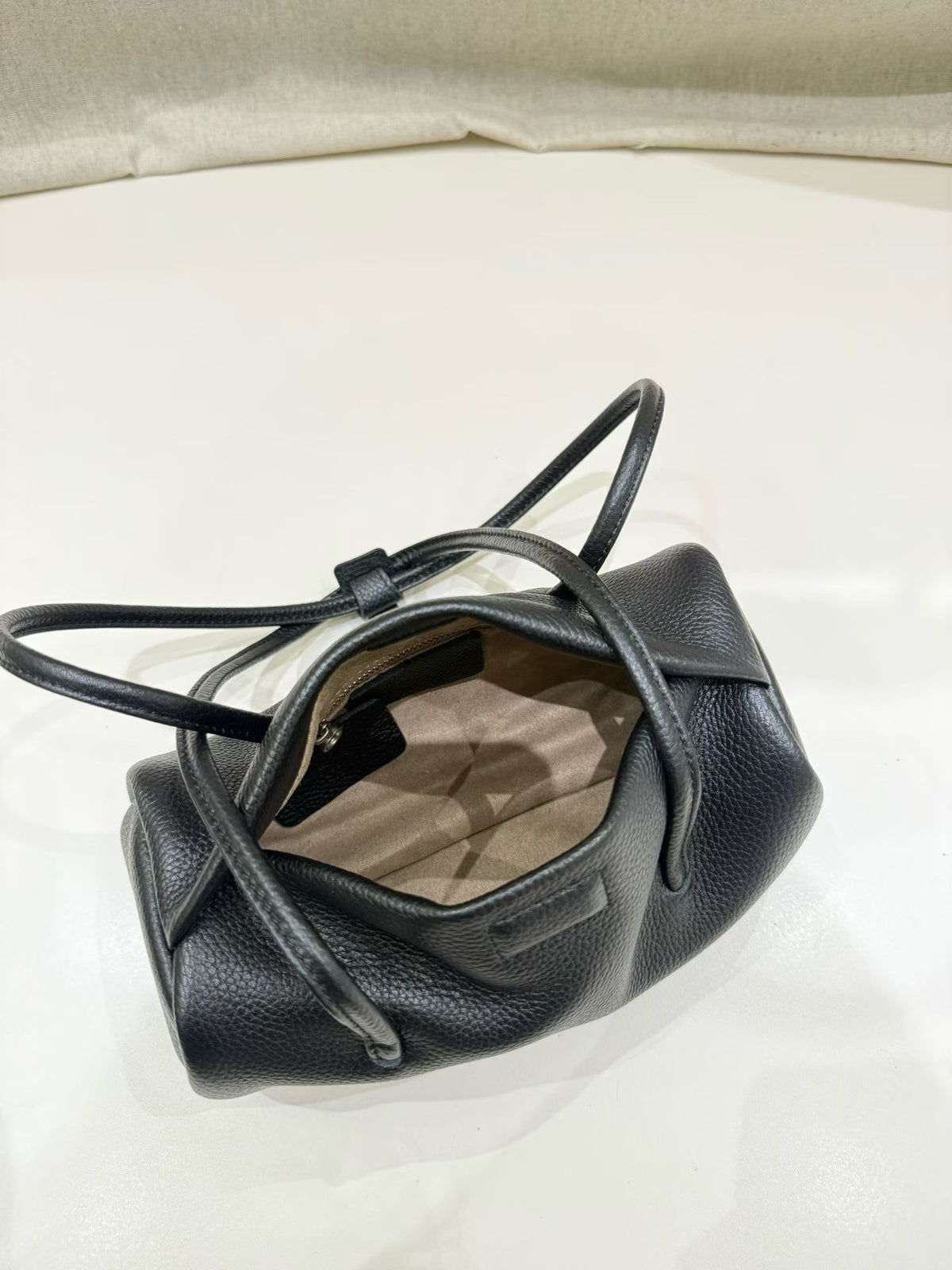 Open black bag showing canvas lining and interior pocket
