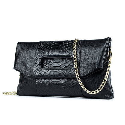 Angled view of black croc-embossed envelope clutch and flap front