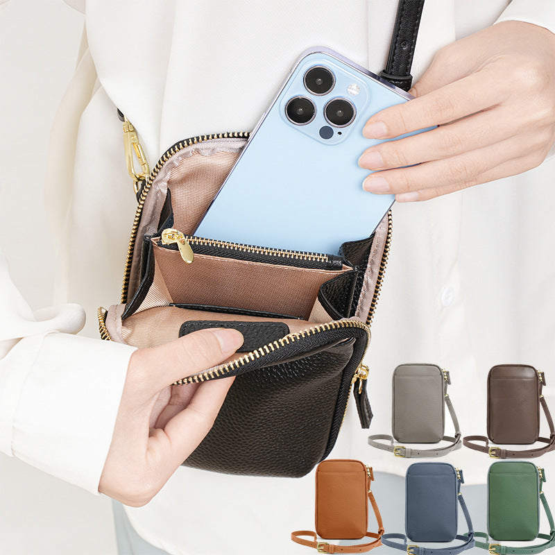 Model sliding a smartphone into the main zip compartment of a black leather phone bag