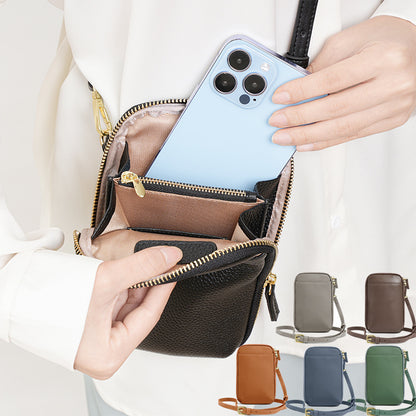 Model sliding a smartphone into the main zip compartment of a black leather phone bag