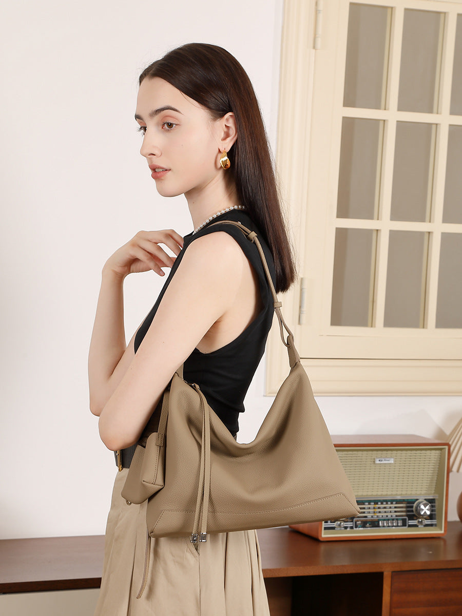 Side view of model wearing gray cowhide leather hobo shoulder bag