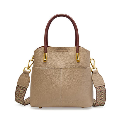Gray cowhide leather bucket bag with top handles and woven strap on white background