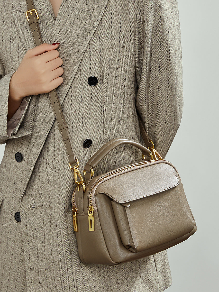 Side view of taupe Boston crossbody bag worn over the shoulder with adjustable strap