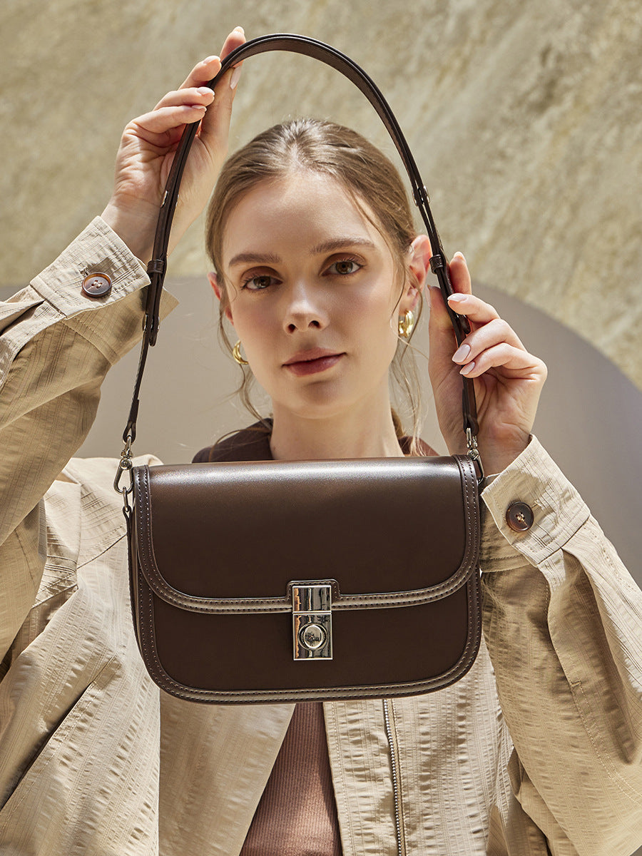 Cowhide leather messenger crossbody bag in brown worn over the shoulder