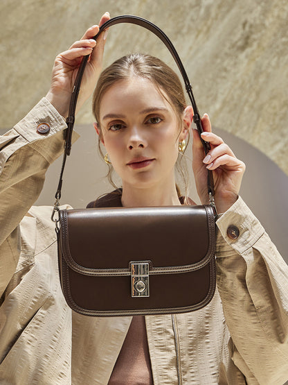 Cowhide leather messenger crossbody bag in brown worn over the shoulder