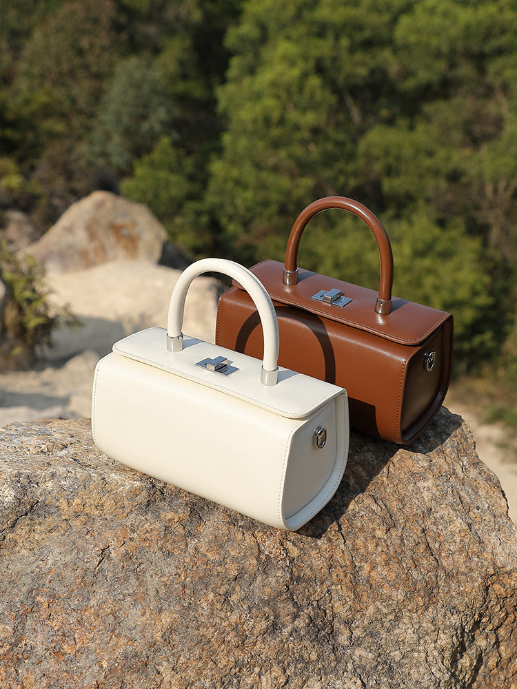 Cream and coffee brown box handbags displayed together on a stone surface