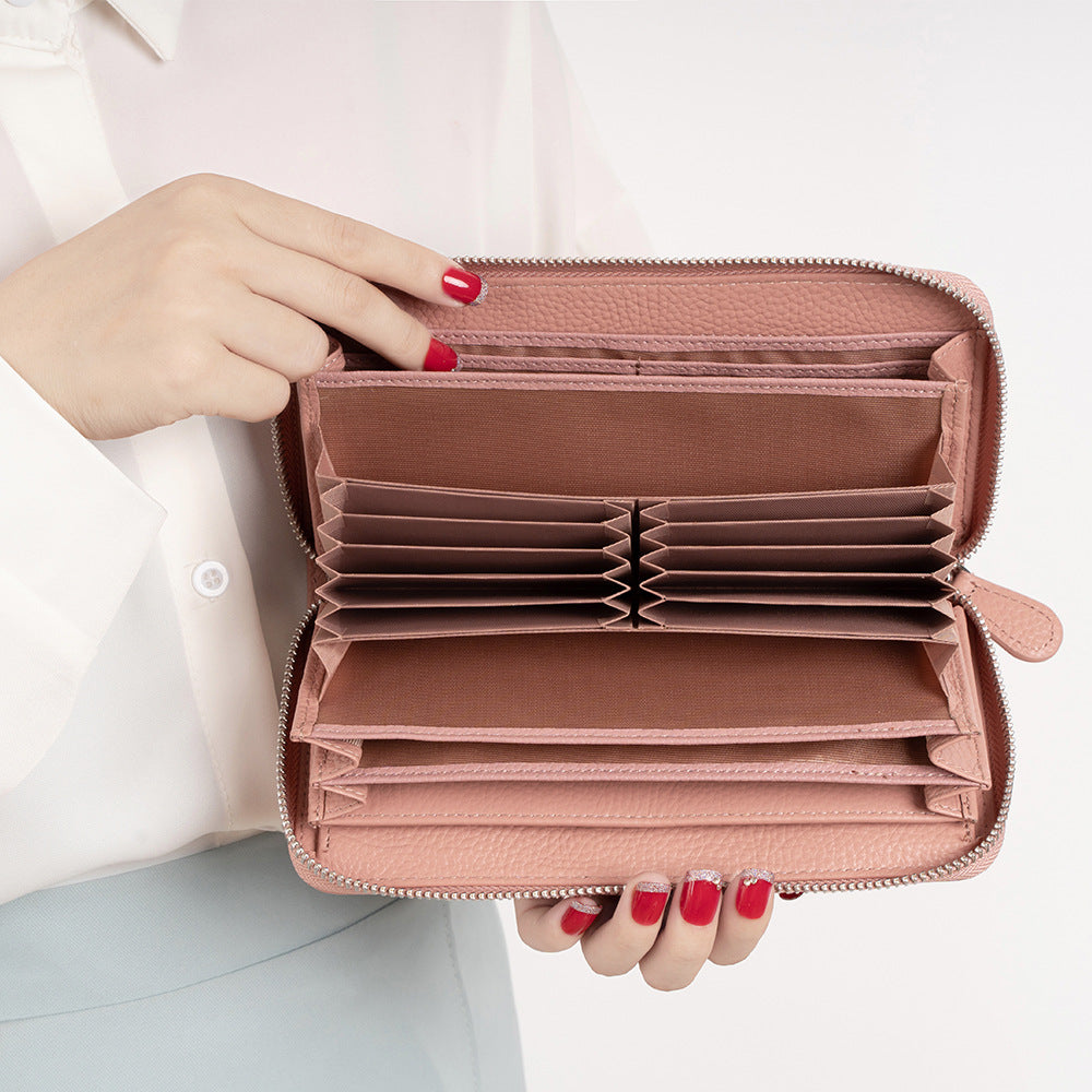 Hand holding open pink wallet showing interior organization