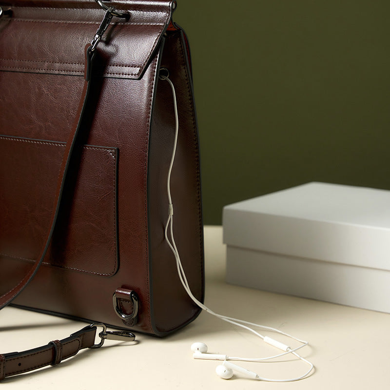 Side detail of brown backpack showing headphone port and earbuds