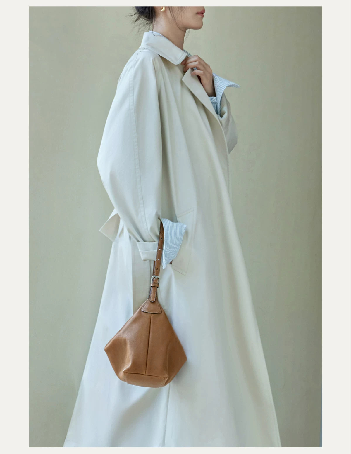 Brown leather hobo bag shown from the side while worn