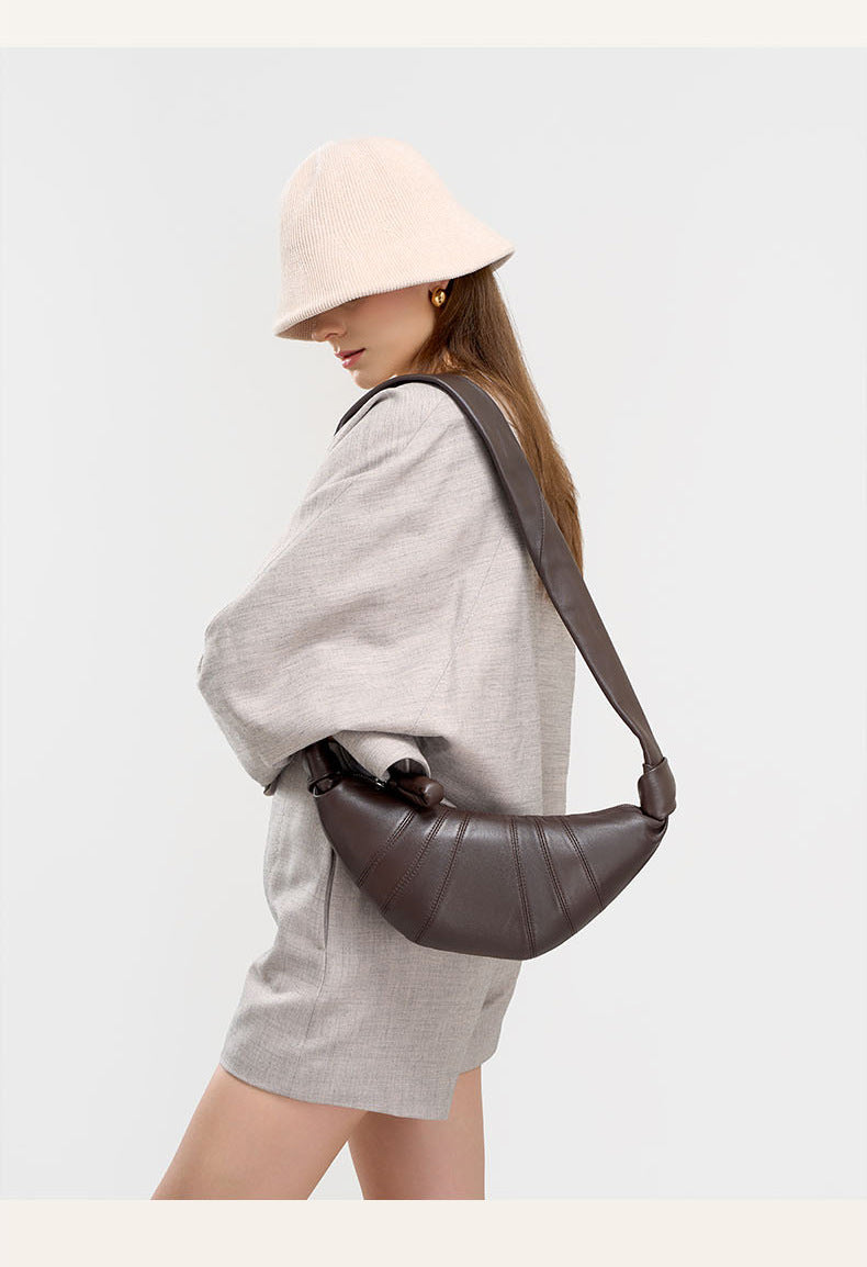 Side view of model in beige hat with coffee crescent shoulder bag
