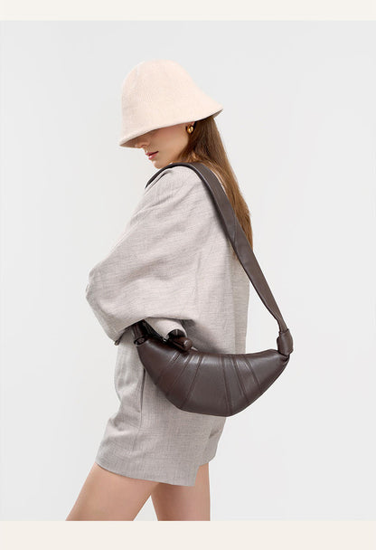 Side view of model in beige hat with coffee crescent shoulder bag