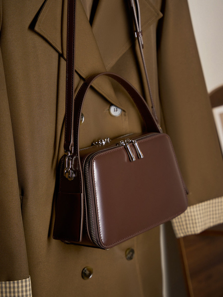 Side view of the coffee brown leather crossbody bag worn over the shoulder